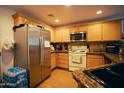 Well-lit kitchen featuring wooden cabinets, granite countertops, and stainless steel appliances, designed for culinary enthusiasts at 3150 E Beardsley Rd # 1105, Phoenix, AZ 85050
