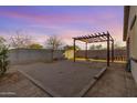 The backyard offers a pergola with string lights, a sand area, and block fencing at 35751 N Bandolier Dr, San Tan Valley, AZ 85144