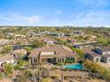 Aerial shot of the backyard features a pool, patio, desert landscaping, and views of the neighborhood at 37170 N Granite Creek Ln, Carefree, AZ 85377