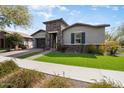 Charming single-story home featuring a stone accented entrance, manicured lawn and attached two car garage at 4683 N 206Th Ln, Buckeye, AZ 85396