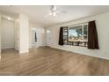 Bright and airy living room featuring light wood floors and a large window at 53040 W Whirly Bird Rd, Maricopa, AZ 85139