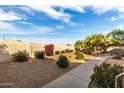 The backyard features a concrete walkway, gravel, multiple bushes, and a vibrant blue sky above at 7101 W Beardsley Rd # 722, Glendale, AZ 85308