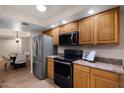 Lovely kitchen featuring wood cabinets and stainless steel appliances adjacent to a dining area at 12222 N Paradise Village S Pkwy # 224, Phoenix, AZ 85032