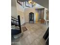 Inviting foyer features high ceilings, tile floors, a modern chandelier, and staircase at 1302 E Tierra Buena Ln, Phoenix, AZ 85022