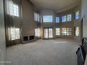 Spacious living room featuring large windows, high ceilings, neutral colors, and a fireplace at 1302 E Tierra Buena Ln, Phoenix, AZ 85022