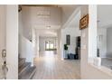 Spacious foyer with high ceilings, tile flooring, and staircase leading to upper level at 16918 W Statler St, Surprise, AZ 85388