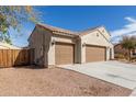 Spacious three-car garage with brown doors, side access gate, and ample driveway space at 17462 W Straight Arrow Ln, Surprise, AZ 85387