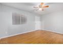 A bright bedroom with wood-look floors, ceiling fan, and a window with blinds at 18202 N Cave Creek Rd # 134, Phoenix, AZ 85032