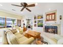 Spacious living room with a cozy fireplace, comfortable seating, and views of the landscaped yard at 20044 N London Bridge Dr, Surprise, AZ 85387