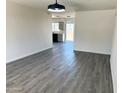 Spacious living room with grey wood floors, bright light fixture and open access to the kitchen at 2018 W Western Dr, Chandler, AZ 85224