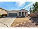 Inviting single-story home with attached garage and covered porch, complemented by well-maintained landscaping at 21333 N Denton Dr, Maricopa, AZ 85138