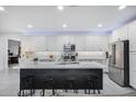 Bright kitchen with ample white cabinetry, stainless steel appliances, and a large island with seating at 25658 N 140Th Ln, Surprise, AZ 85387