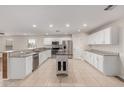 Bright, open kitchen features white cabinetry, granite countertops, and a center island at 25723 S Hawes Rd, Queen Creek, AZ 85142