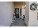 Charming covered front entry featuring decorative accents and a wreath on the exterior wall at 2621 S 157Th Dr, Goodyear, AZ 85338