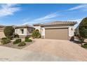 Attractive single-story home with well-kept desert landscaping, a brick-paved driveway, and a convenient two-car garage at 26616 W Quail Ave, Buckeye, AZ 85396