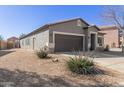 Well-maintained home exterior featuring desert landscaping, neutral tones, and an attached two-car garage at 28933 N Saddle Way, San Tan Valley, AZ 85143