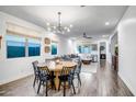 Open living area with dining table, modern lighting, and wood-look floors at 3010 W Laredo Ln, Phoenix, AZ 85085