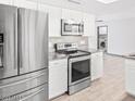 Modern kitchen with stainless steel appliances, white cabinets and granite countertops at 3227 E Enid Ave, Mesa, AZ 85204