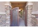 Elegant entry gate showcasing stone pillars and a decorative wrought iron design at 5090 S Pinaleno Pl, Chandler, AZ 85249