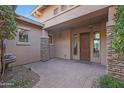 Inviting front porch featuring a water feature, elegant stonework, and a classic wooden door at 5090 S Pinaleno Pl, Chandler, AZ 85249