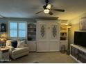 Cozy living room featuring a murphy bed, comfortable armchair, and ample shelving at 6161 S Pinehurst Dr, Chandler, AZ 85249