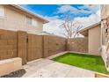 Enclosed backyard with artificial grass, block wall, and patio, offering a low-maintenance outdoor retreat at 8532 E Belleview St, Scottsdale, AZ 85257