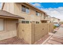 Exterior view of the home with a private patio area and a second-story balcony at 8532 E Belleview St, Scottsdale, AZ 85257