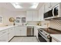 Bright kitchen showcasing white cabinets, stainless steel appliances, and a window over the sink at 8653 E Royal Palm Rd # 2019, Scottsdale, AZ 85258