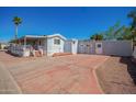 Manufactured home featuring a detached garage, covered porch, and a long driveway at 8823 E Billings St, Mesa, AZ 85207