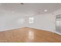 Living room featuring hardwood floors, white walls, natural lighting, and baseboards at 8823 E Billings St, Mesa, AZ 85207