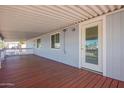 Covered porch featuring dark wood flooring, white railings, and natural lighting at 8823 E Billings St, Mesa, AZ 85207