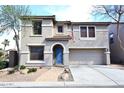 Two-story home with blue front door, attached garage, and manicured front yard at 1293 E Clifton Ave, Gilbert, AZ 85295
