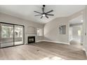 Light-filled living room with a fireplace, sliding glass doors, ceiling fan, and neutral paint at 15050 N Thompson Peak Pkwy # 2036, Scottsdale, AZ 85260