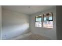 Well-lit bedroom with dual windows offering great natural light and an unfinished floor at 15764 W Beryl Ave, Waddell, AZ 85355