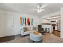 Living room featuring a ceiling fan and a view to the Kitchen with white cabinets at 1720 E Thunderbird Rd # 2078, Phoenix, AZ 85022
