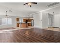 Spacious open-concept living area featuring hardwood floors, a ceiling fan, and an open kitchen at 2145 E Danbury Rd, Phoenix, AZ 85022