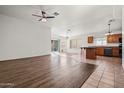 Bright living room and kitchen with hardwood floors, ceiling fan, and sliding glass door to the back yard at 2145 E Danbury Rd, Phoenix, AZ 85022