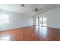 Open-concept living room with wood floors, vaulted ceilings, and sliding glass doors to the backyard at 2444 S Terrell --, Mesa, AZ 85209