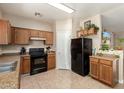 A cozy kitchen features brown cabinetry and essential appliances at 36579 W Barcelona Ln, Maricopa, AZ 85138