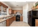 A cozy kitchen features brown cabinetry and essential appliances at 36579 W Barcelona Ln, Maricopa, AZ 85138