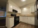 Efficient kitchen featuring white cabinets, black appliances, and a window view at 3810 W Belmont Ave, Phoenix, AZ 85051