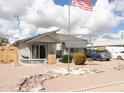 Single-story home with an American flag, desert landscaping, and covered parking at 614 S 92Nd Pl, Mesa, AZ 85208