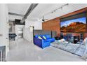 Stylish living room boasting exposed brick, a plush blue sofa, and a large screen at 7301 E 3Rd Ave # 121, Scottsdale, AZ 85251