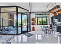 Bright living room featuring large windows, sleek floors, and modern decor leading into the kitchen at 7301 E 3Rd Ave # 121, Scottsdale, AZ 85251