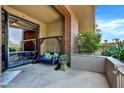 Relaxing patio featuring a swing, lush greenery, and a tiled floor at 7301 E 3Rd Ave # 121, Scottsdale, AZ 85251