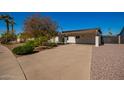 Spacious carport and driveway leading to a well-maintained home with mature landscaping at 904 W Juanita Ave, Mesa, AZ 85210