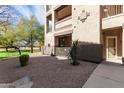 Condo exterior showing a private patio with neutral colors, a small garden and mature tree at 10136 E Southern Ave # 1114, Mesa, AZ 85209