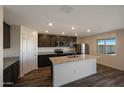 Modern kitchen with stainless steel appliances, granite countertops, and large central island at 1057 W West Virginia Ave, Florence, AZ 85132