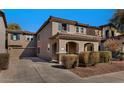 Inviting two-story home with an attached two-car garage, tile roof, and a charming arched entryway with manicured landscaping at 10938 W Pierson St, Phoenix, AZ 85037
