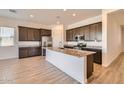 Modern kitchen featuring granite countertops, stainless steel appliances, and dark wood cabinets at 15032 W Gray Fox Trl, Surprise, AZ 85387